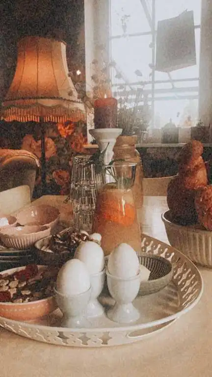 Frühstückstisch mit Eiern, Croissant und Orangensaft